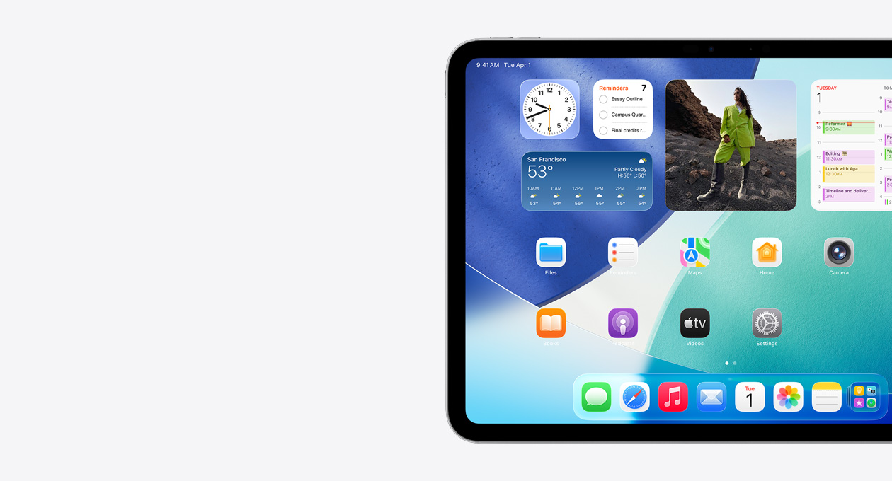 横屏放置的 iPad，仅展示屏幕左侧，主屏幕具有叠放的小组件，包括呈现 Liquid Glass 效果的半透明时钟、提醒事项 app、天气小组件、两排较小的 app 以及程序坞。