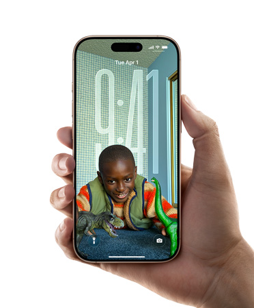 手持 iPhone 设备的画面，展示全新 Liquid Glass 设计，时间可随锁定屏幕上的图像动态调整。