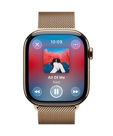 金色钛金属 Apple Watch 搭配米兰尼斯表带，表盘显示 Apple Music 正在播放音乐，控制按钮为半透明的 Liquid Glass 设计。